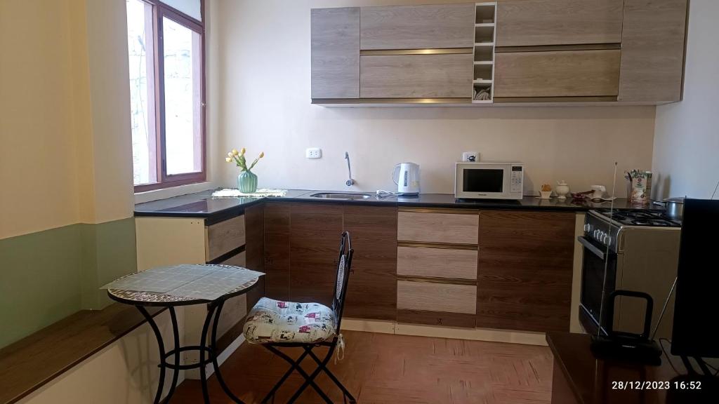 une petite cuisine avec une table et un four micro-ondes dans l'établissement Habitación totalmente independiente con cocina, baño, balcón super espacioso, à Arequipa