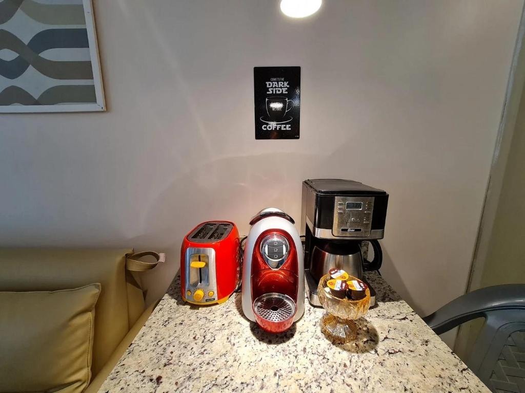Tabatinga Residence Flat Family Kids 04 في كوندي: كونتر توب مع آلة صنع القهوة ومحمصة