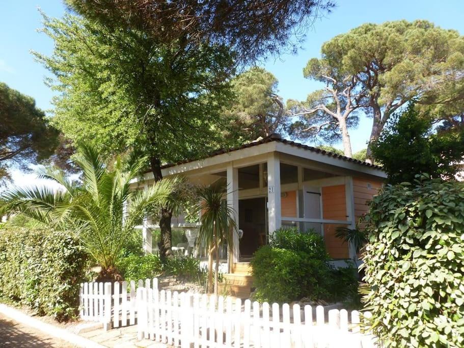 uma casa com uma cerca branca em frente em GASPRO21 - Golfe de Saint-Tropez, chalet californien pour 8 personnes em Gassin