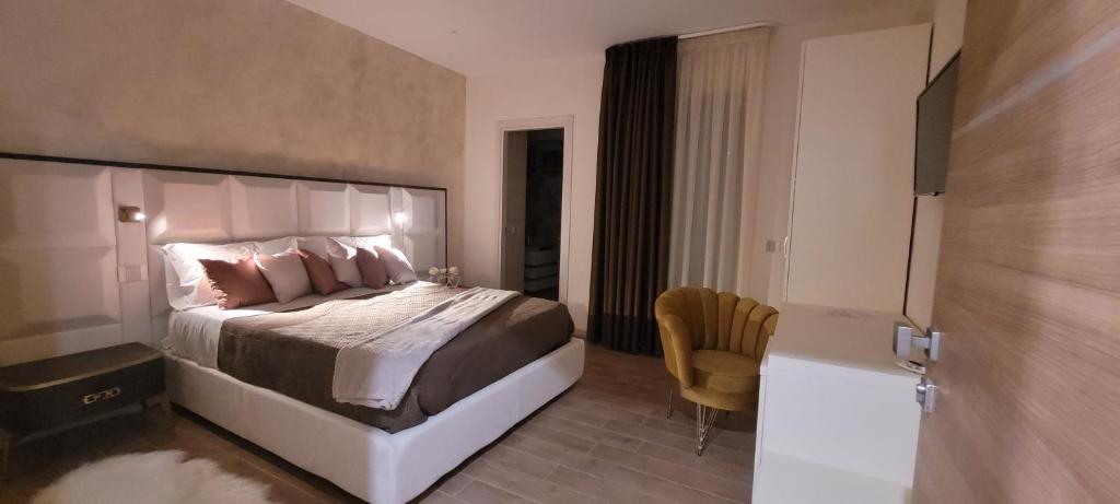 ein Schlafzimmer mit einem großen Bett und einem Stuhl in der Unterkunft Villa Nasti Luxury Bed Taurasi Room in Nocera Inferiore