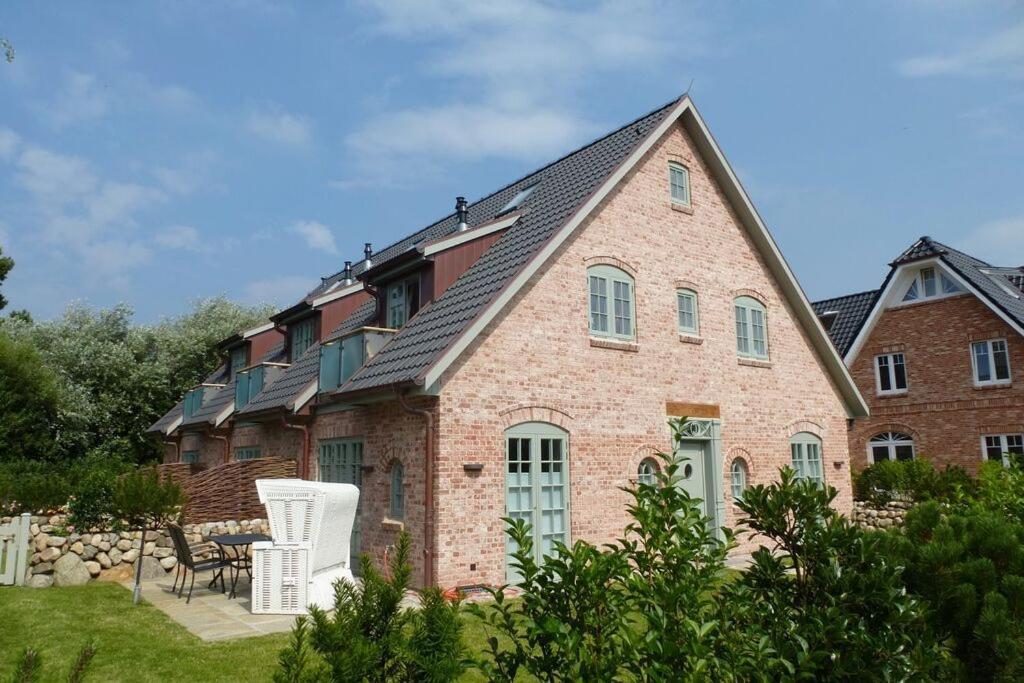 ein großes Backsteinhaus mit schwarzem Dach in der Unterkunft Haus Magnus, App 4 in Wenningstedt-Braderup
