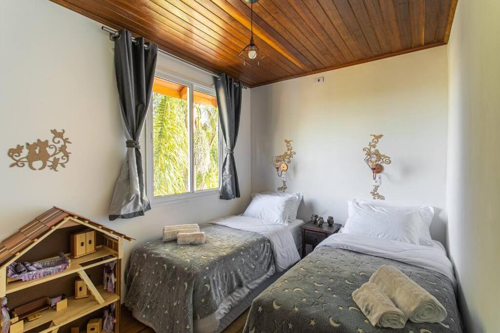1 Schlafzimmer mit 2 Betten und einem Fenster in der Unterkunft Schatz Chalé Witmarsum in Palmeira