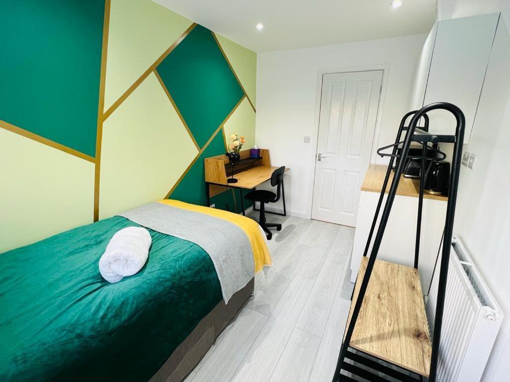 een slaapkamer met een bed en een bureau bij Stylish studio in Milton Keynes