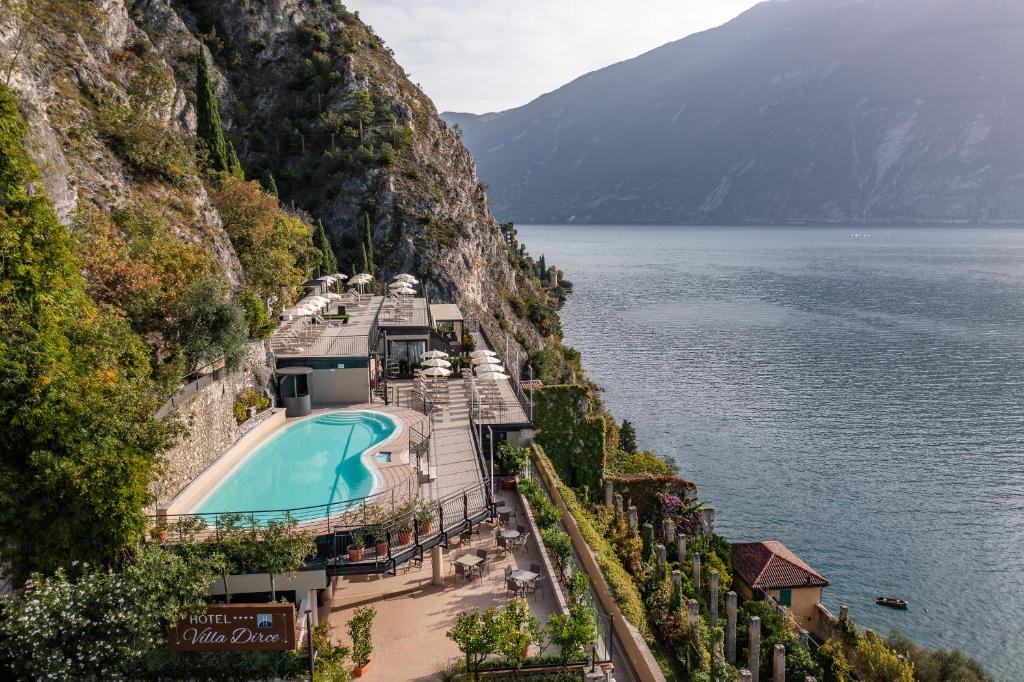 a resort on the side of a mountain next to the water at Hotel Villa Dirce in Limone sul Garda