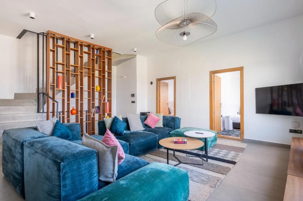 un salon avec des canapés bleus et une télévision dans l'établissement Maison Perle de Marshan, à Tanger