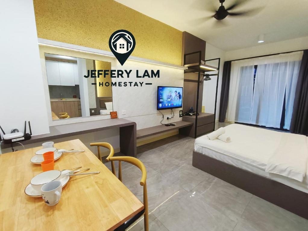 Cette chambre comprend un lit, une table et une télévision. dans l'établissement Imperio Residence Melaka by Jeffery Lam Home Management, à Malacca