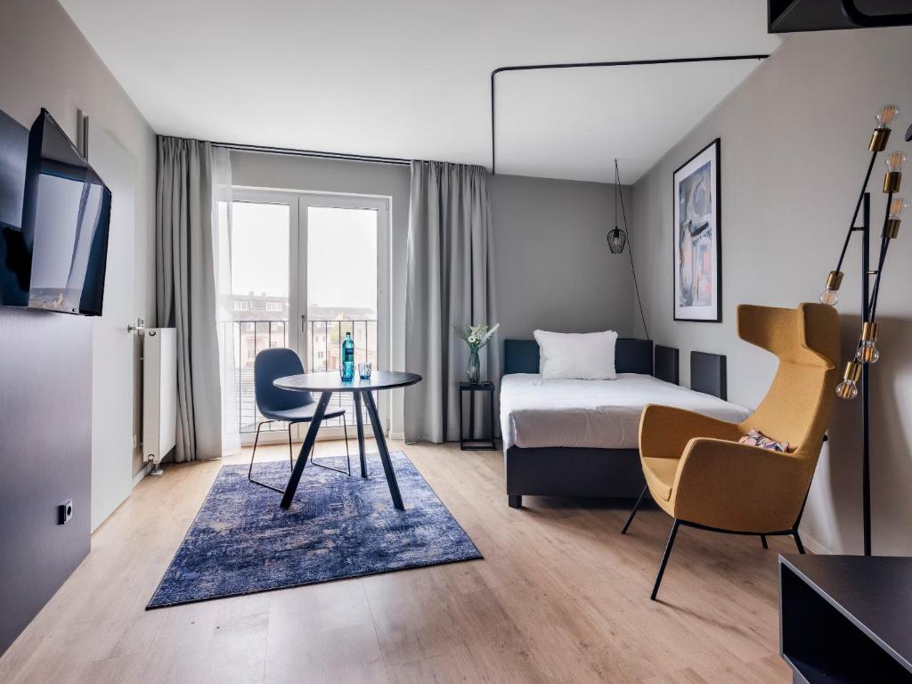 een hotelkamer met een bed en een tafel en stoelen bij numa I Bloc Rooms & Apartments in Frankfurt am Main