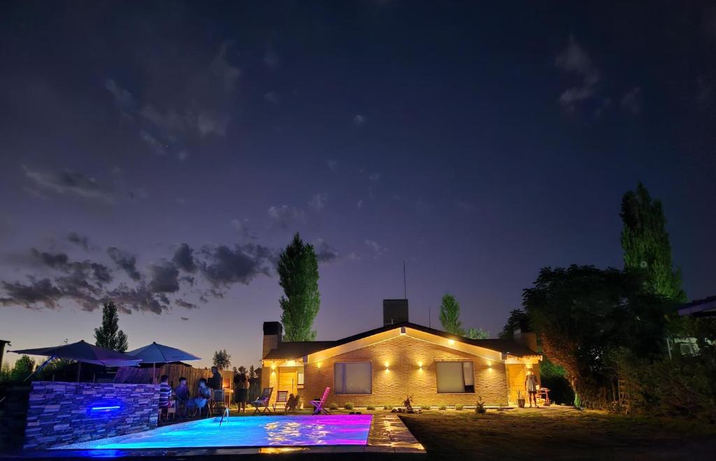 una casa con piscina por la noche en Cabañas Golden en San Rafael