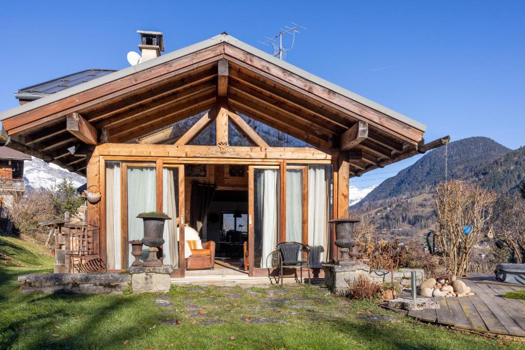 a log cabin with a porch with a fireplace at Le Solli in Saint-Gervais-les-Bains