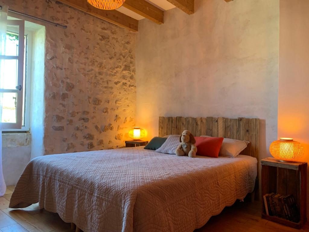 een teddybeer op een bed in een slaapkamer bij La Magnanerie de Dions in Dions