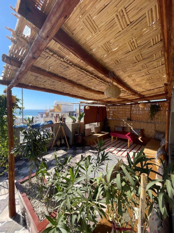 an outdoor patio with a wooden pergola at ASNFU AUBERGe in Imsouane