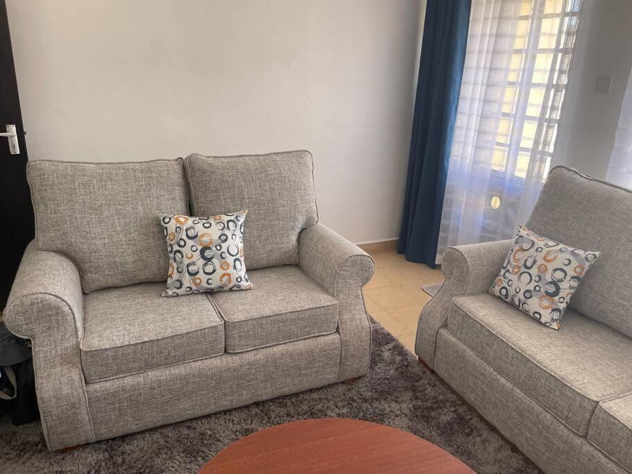 a living room with a couch and a chair at Hillmaac Nest in Eldoret