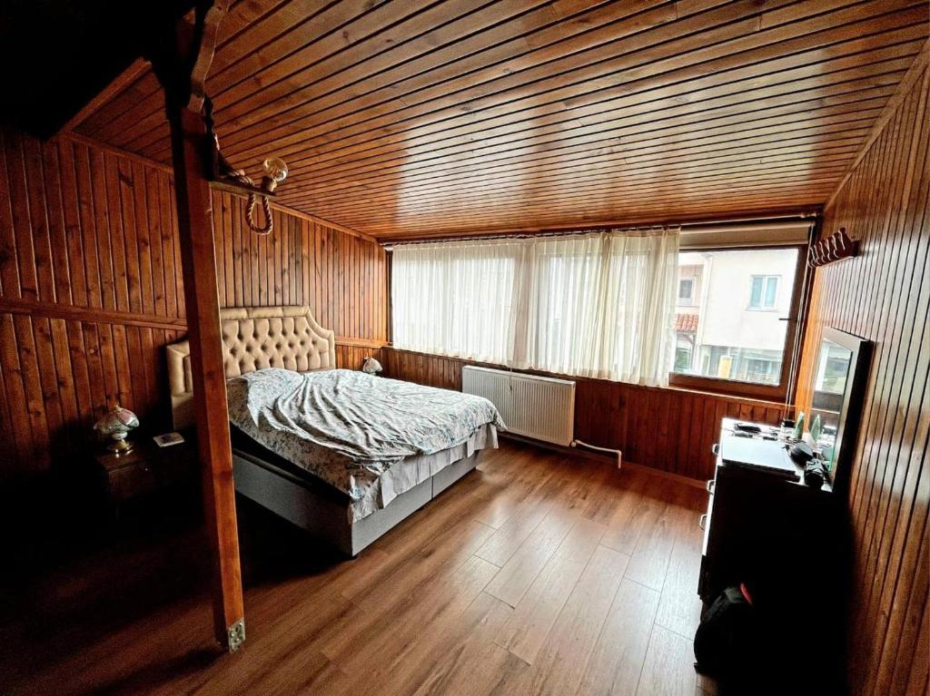 a bedroom with a bed in a room with wooden walls at Halic Apart Hotel in Yalova