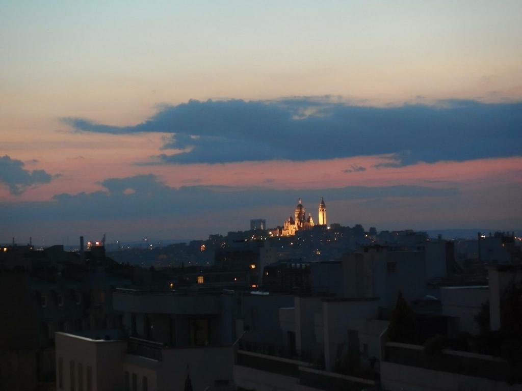 a view of a city skyline at sunset at Le Nid D'Aigle in Paris