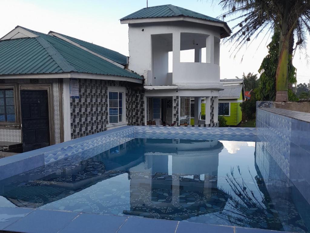 a house with a swimming pool in front of a building at CRYSTAL HOMES Air BnB in Mumias