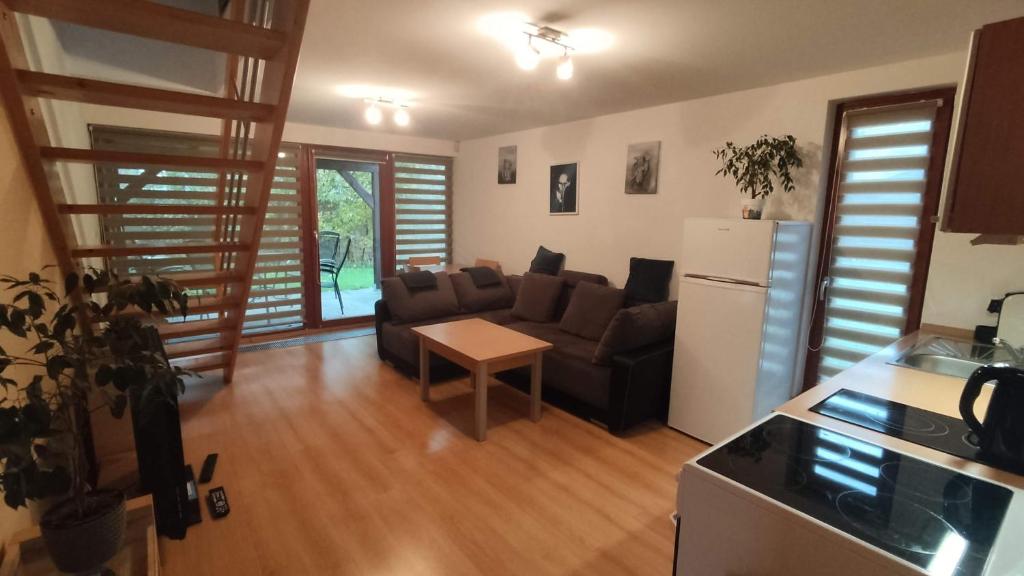 a kitchen and a living room with a couch and a refrigerator at Rodinný Apartmán Adléta in Horní Bečva