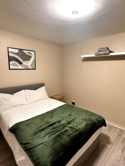 una camera da letto con un letto con una coperta verde sopra di Apartment in Greenwich a Londra