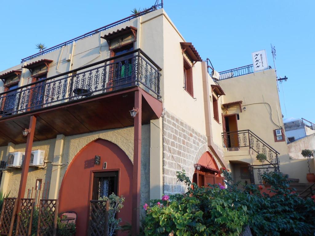 a building with a balcony on the side of it at Niki's Pension in Rhodes Town