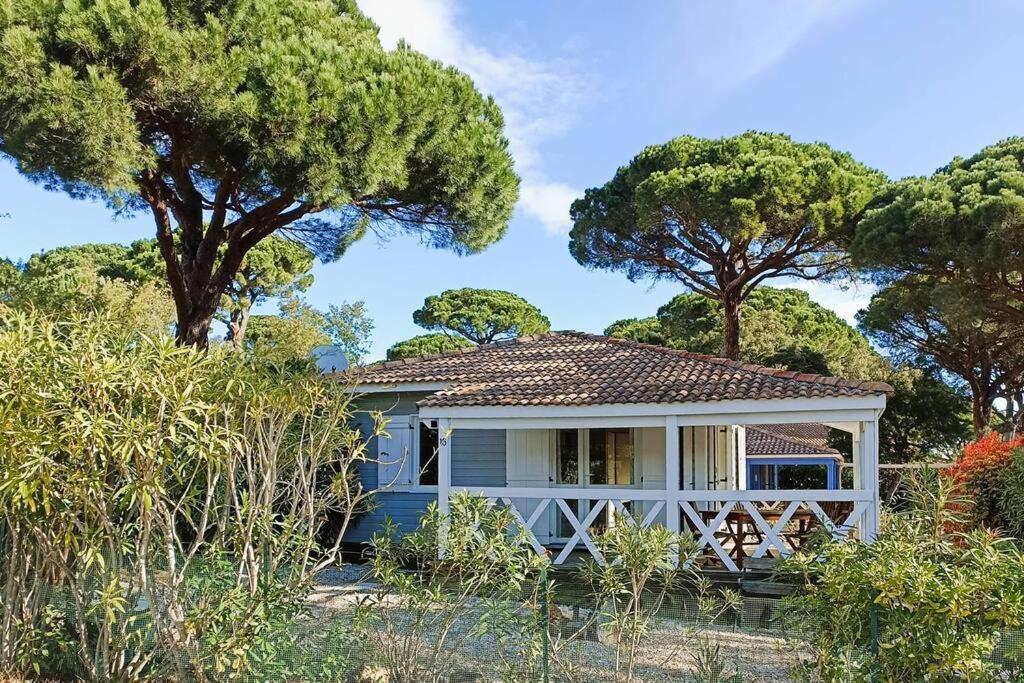 une petite maison bleue avec des arbres en arrière-plan dans l'établissement GASPRO16 - Golfe de Saint-Tropez - Chalet californien climatisé, à Gassin