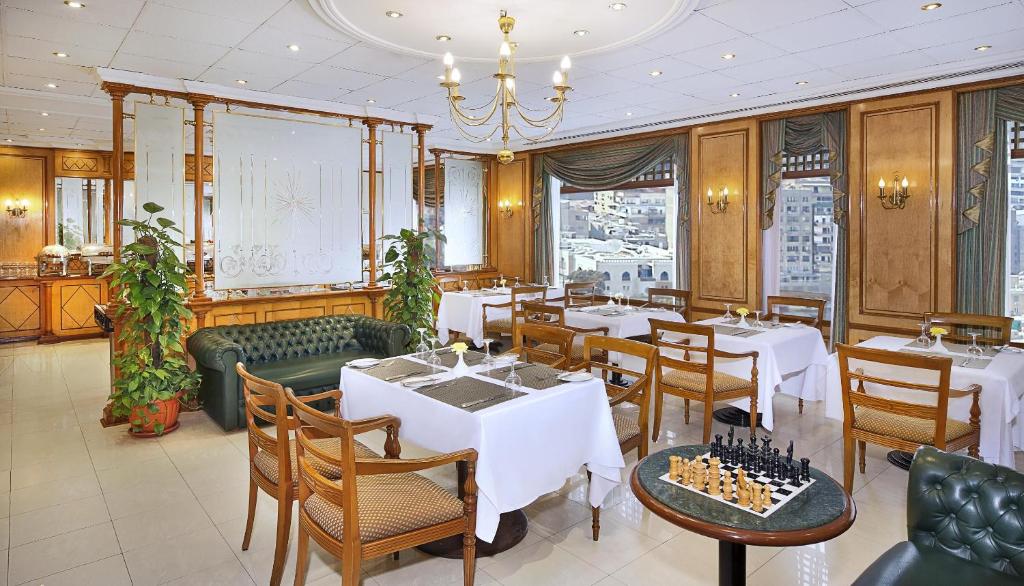 a restaurant with tables and chairs and a chandelier at Cairo World Trade Center Hotel & Residences in Cairo