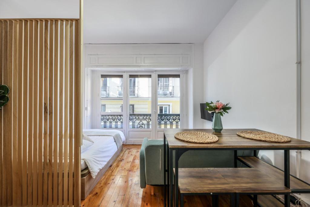 - une salle à manger avec une table et un lit dans l'établissement Victoria Apartments, à Madrid