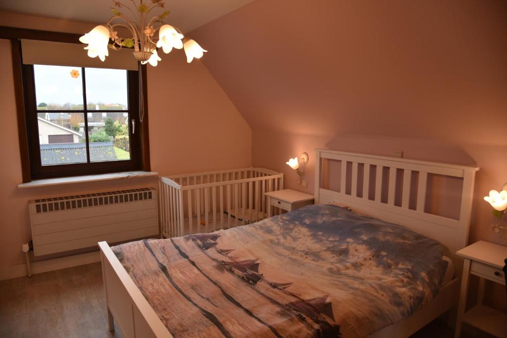 a bedroom with a large bed and a window at Rust aan de kust in Middelkerke