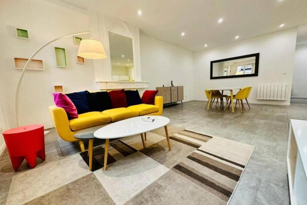 un salon avec un canapé jaune et une table dans l'établissement Remarkable 2-Bed Apartment in Bordeaux, à Bordeaux