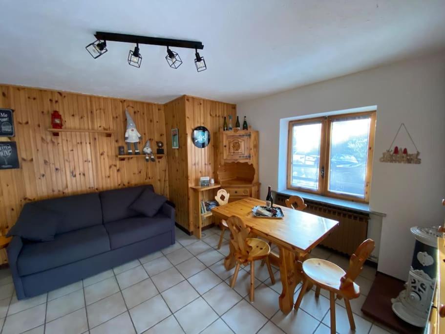 ein Wohnzimmer mit einem blauen Sofa und einem Tisch in der Unterkunft Appartamento Valtournenche in Valtournenche