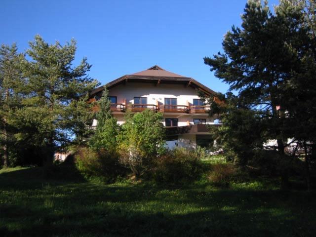 ein großes Gebäude mit Bäumen davor in der Unterkunft Appartements Amrusch in Sankt Jakob im Rosental