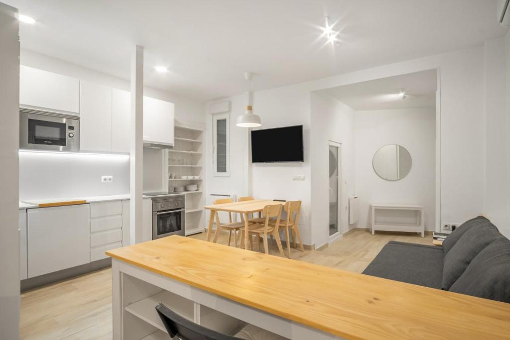 a kitchen and living room with a couch and a table at 1 bedrooms 1 bathroom furnished - La Latina - modern - MintyStay in Madrid