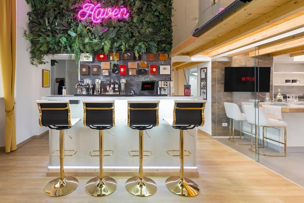 un bancone con sgabelli dorati da bar di Haven Spa Luxury Loft - Como City Centre a Como
