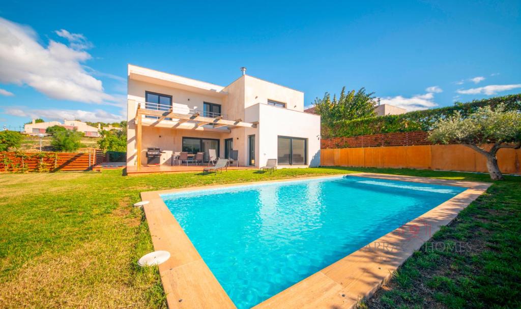 une villa avec une piscine en face d'une maison dans l'établissement TarracoHomes - TH130 Golf y Relax Tarragona Costa Dorada, à Catllar