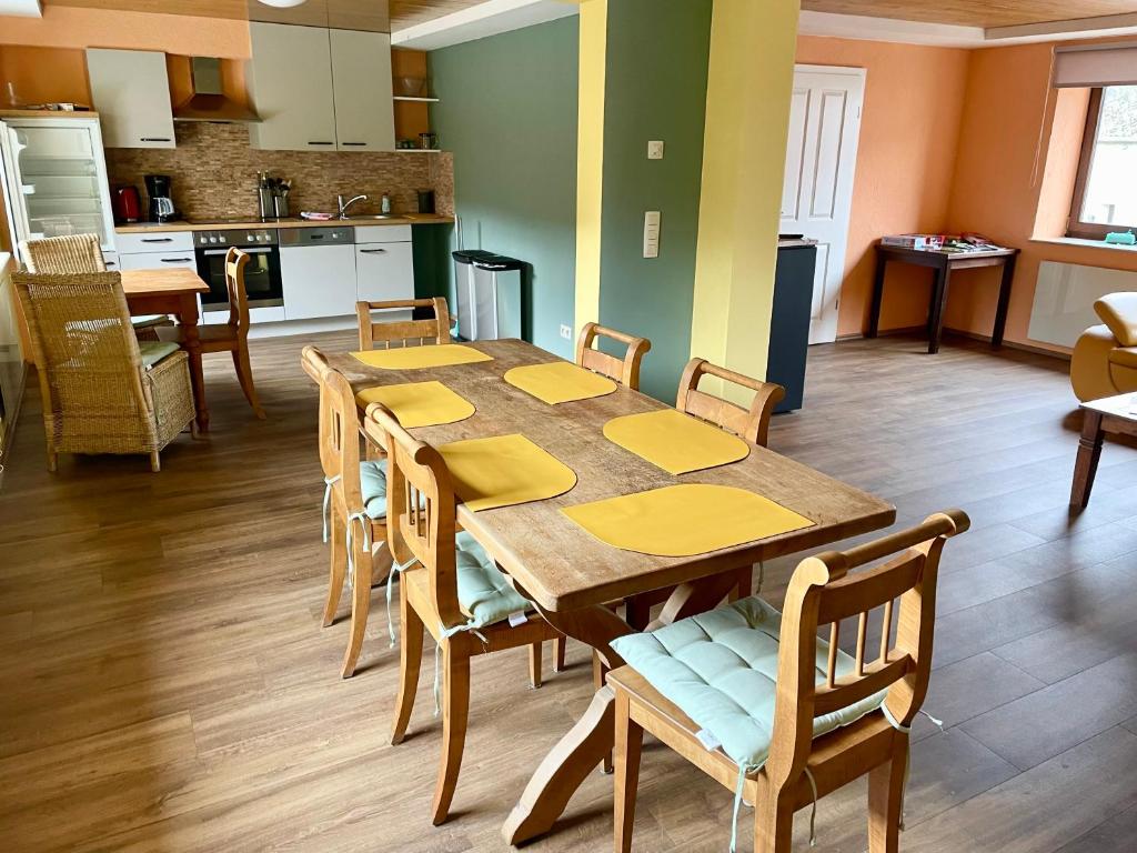 eine Küche und ein Esszimmer mit einem Tisch und Stühlen in der Unterkunft Revival Ranch Ferienhaus in Büllingen