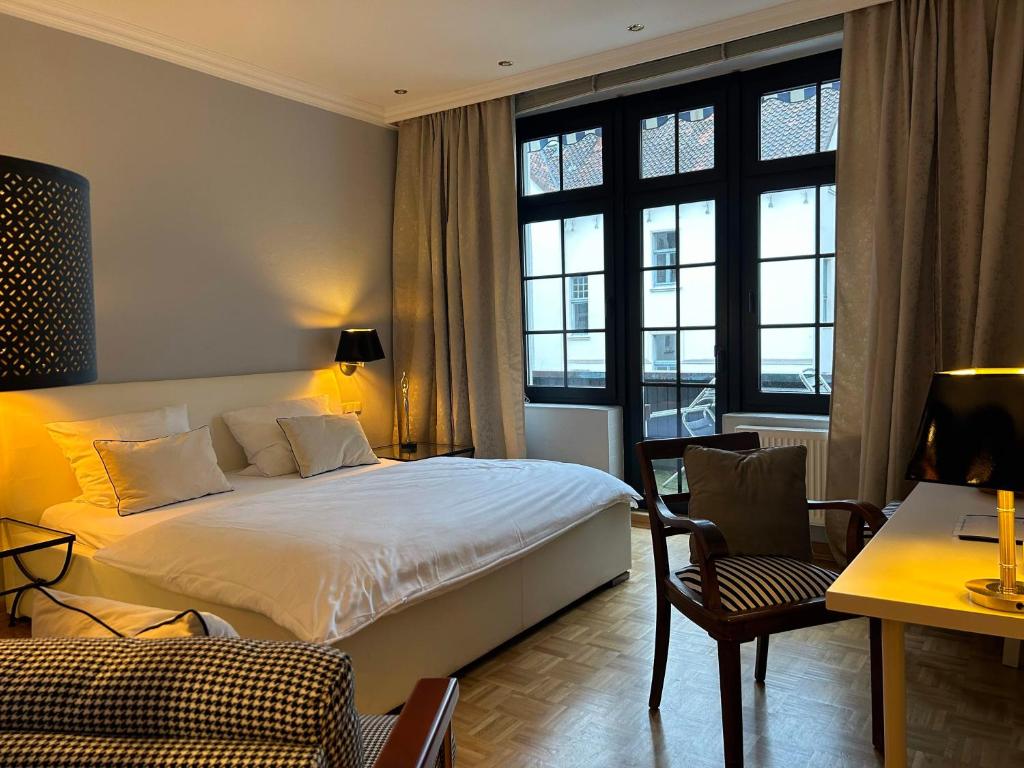 um quarto de hotel com uma cama grande e uma secretária em Appartementhaus Herrenhäuser Gärten em Hanôver