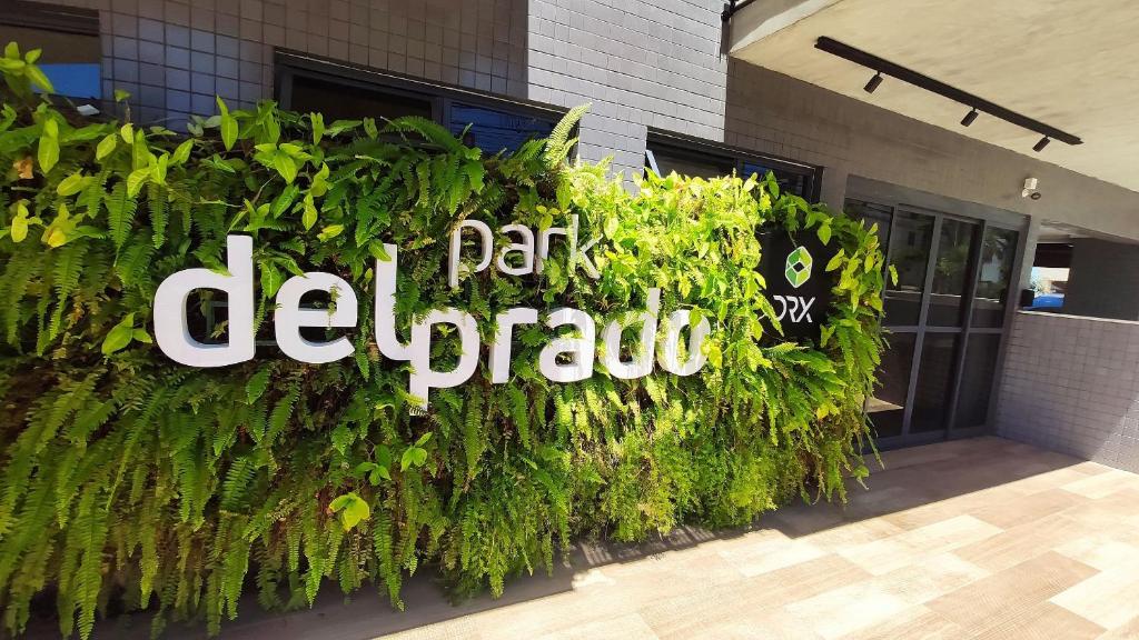 a sign for a building with green plants at Park Del Prado - Intermares in Ilha da Restinga