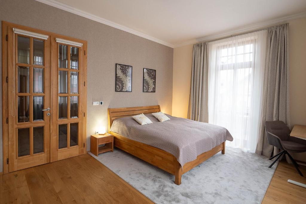 ein Schlafzimmer mit einem Bett und einem großen Fenster in der Unterkunft Executive 2-Bdrm central suite in Ústí nad Labem