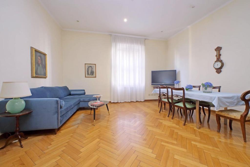 sala de estar con sofá azul y mesa en Spacious Parioli Apartment en Roma