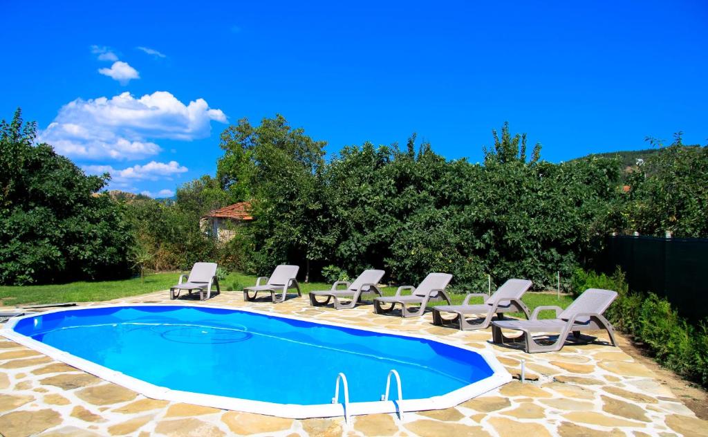 une piscine avec des chaises longues et une piscine dans l'établissement Къща за гости Вила Смокиня град Хисаря, à Hisarya
