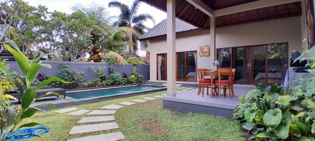 una casa con piscina, tavolo e sedie di Umah Landuh ad Ubud