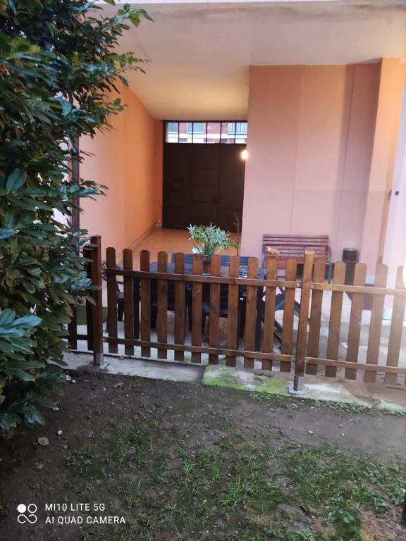 una recinzione di legno di fronte a un edificio di HOSTAL D'ANNUNZIO HOUSe a Cesano Boscone