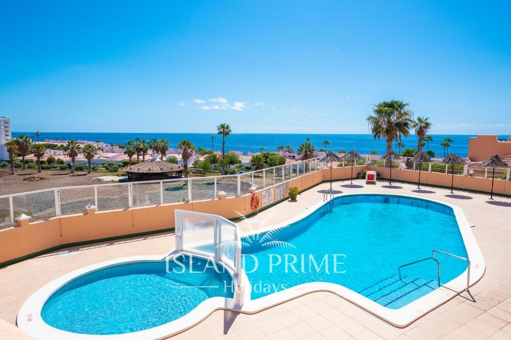 a swimming pool on a balcony with the ocean in the background at Golf and Sea Views Holiday in Golf del Sur in San Miguel de Abona