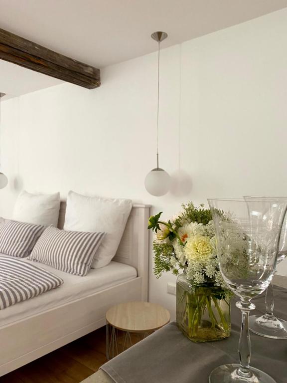 sala de estar con sofá y mesa con un jarrón de flores en Sonnenhof 1737 - Ferienzimmer & Apartments, en Barbelroth