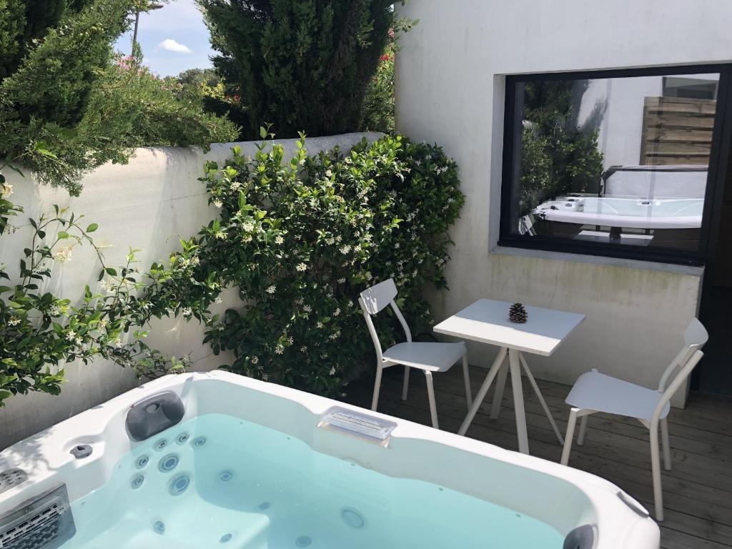 a bath tub sitting on a patio with a table and chairs at Villa Rose in Rivedoux-Plage