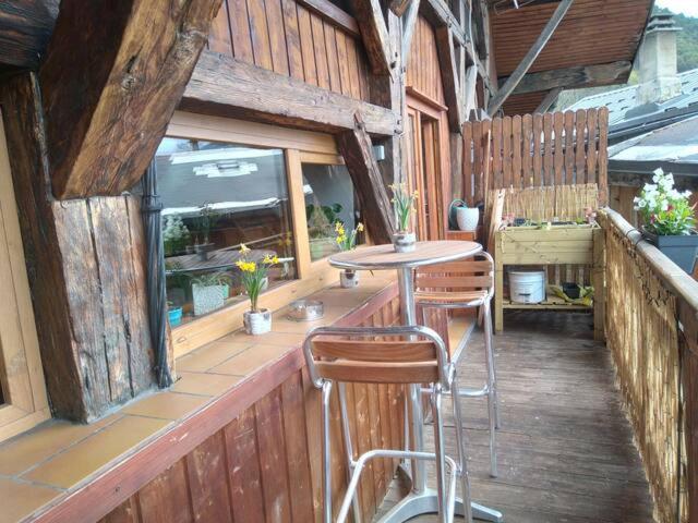 une terrasse en bois avec une table et deux chaises dans l'établissement Charmant duplex 70m2,type châlet savoyard, à Bourg-Saint-Maurice