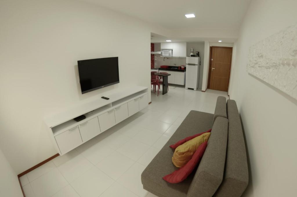 sala de estar con sofá y TV de pantalla plana en Apartamento Completo en Maceió