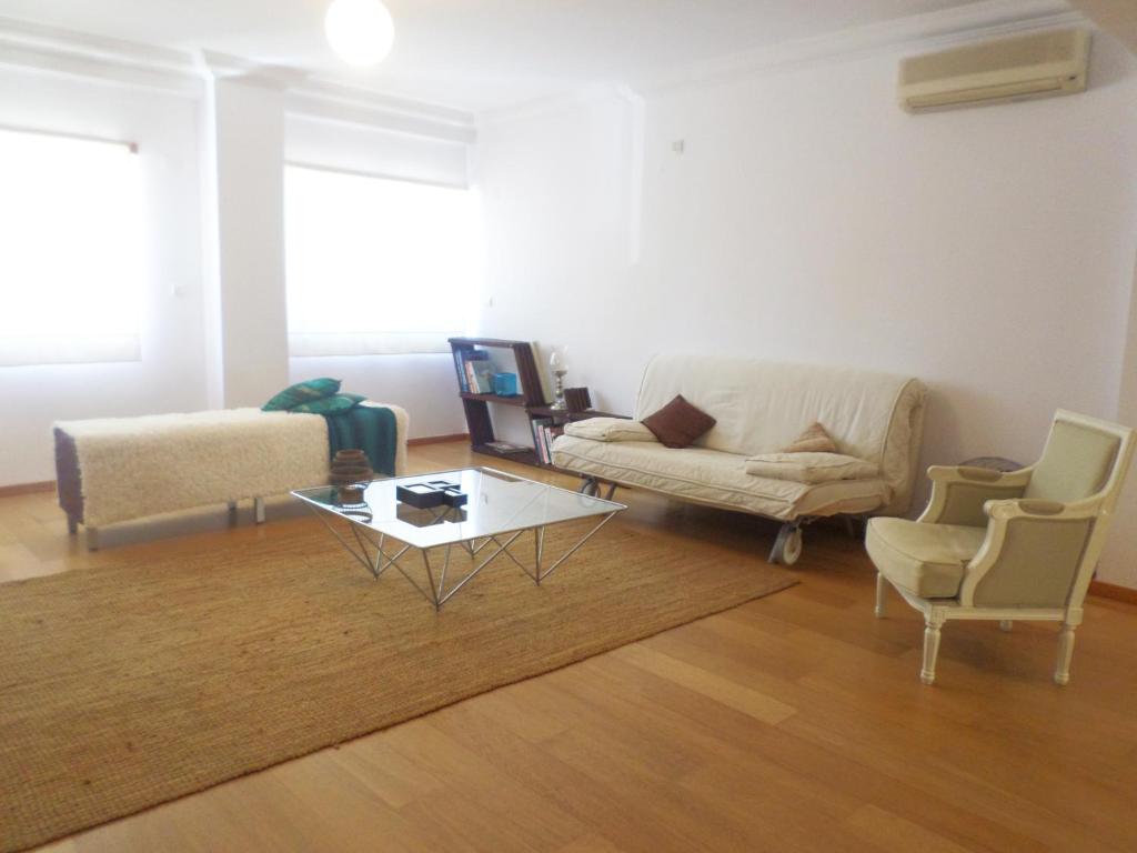 a living room with a couch and a table and chairs at 33 José Farinha in Lisbon
