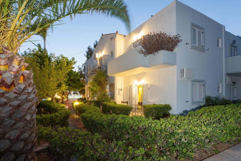 una casa blanca con una palmera al lado de una calle en Rastoni, en Spílion