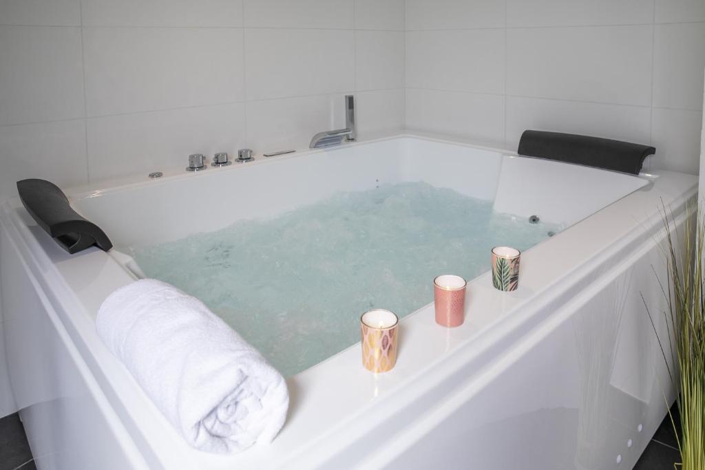 uma banheira com toalhas e velas em Chablis Spa 1er Cru Balnéo em Chablis