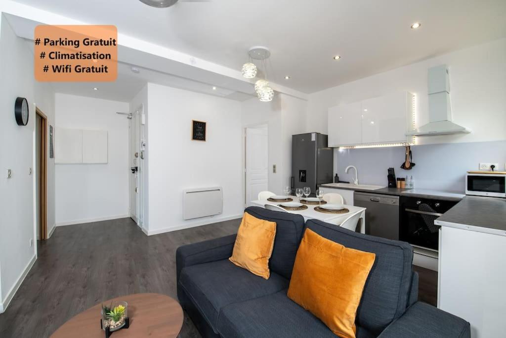 un salon avec un canapé bleu et une cuisine dans l'établissement #Rubis du Sud - Wifi - Clim -Parking - Balcon#, à Toulon