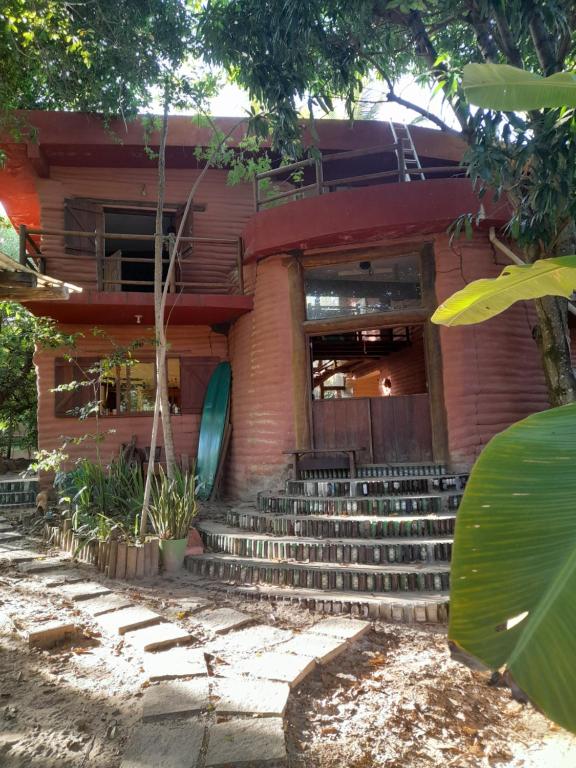 a red brick building with stairs in front of it at Casona de Barro in Imbassai